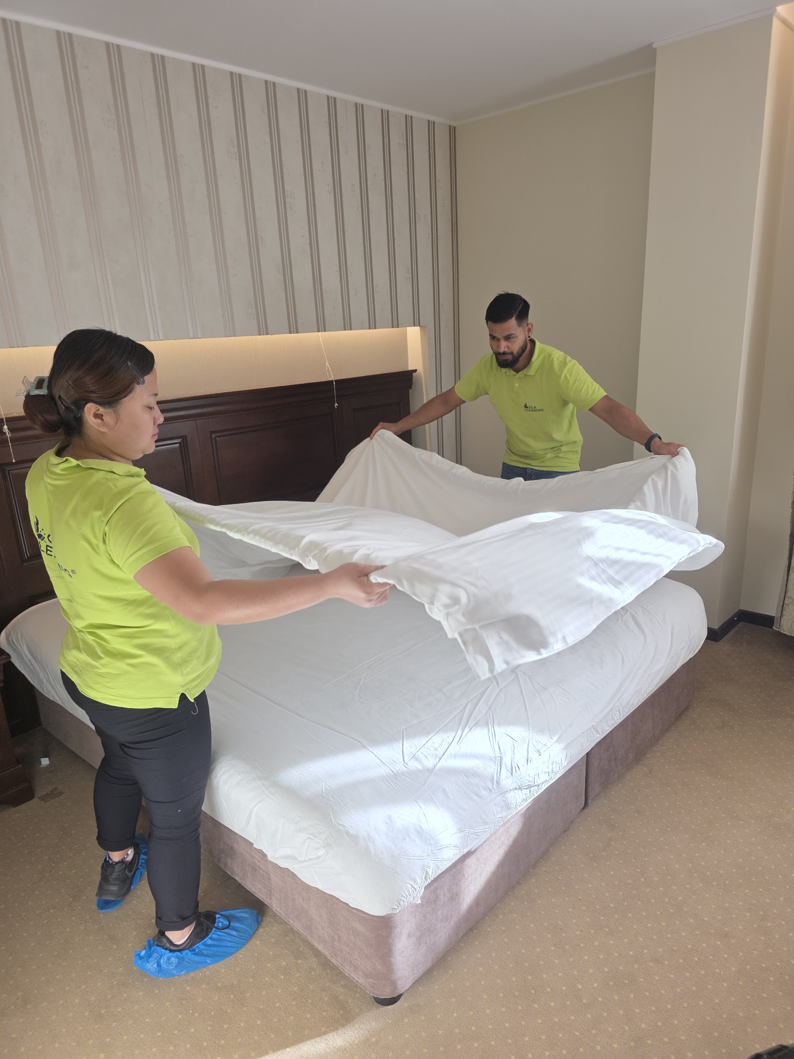 Echipa Ola Cleaning schimbă lenjeria într-un dormitor din Brașov